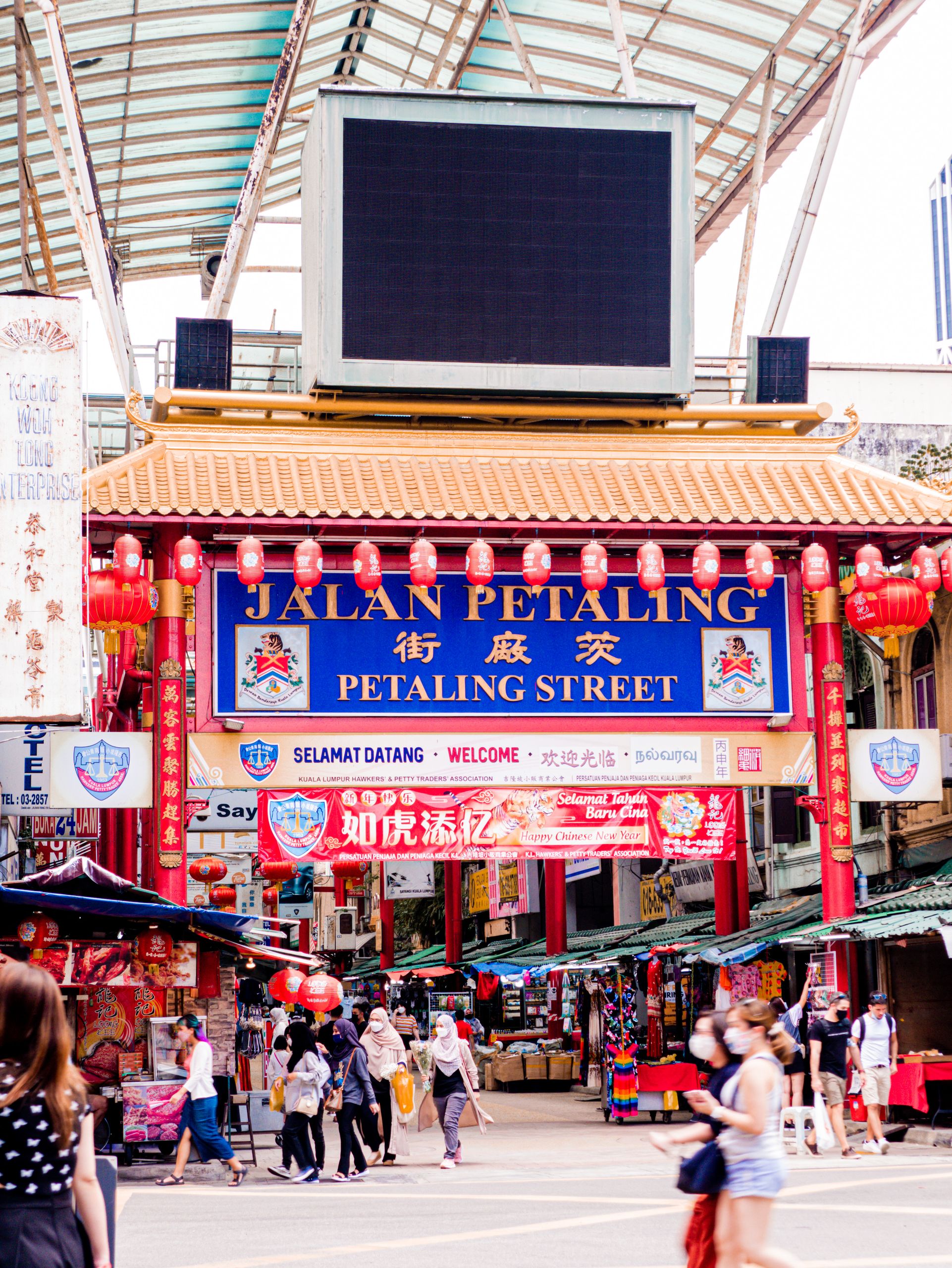 The bustling and colorful entrance to Jalan Petaling in Kuala Lumpur's Chinatown, showcasing cultural vibrancy.